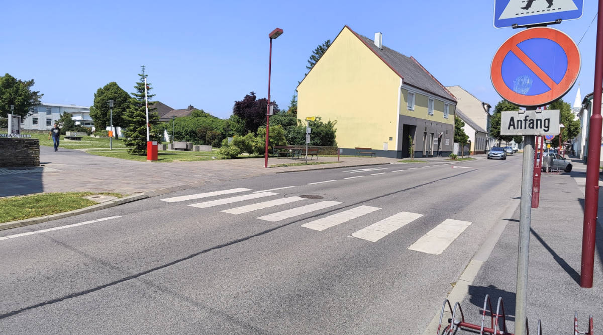 Die Straße vor der Schule weist breite Autospuren und wenig Beschilderung auf.